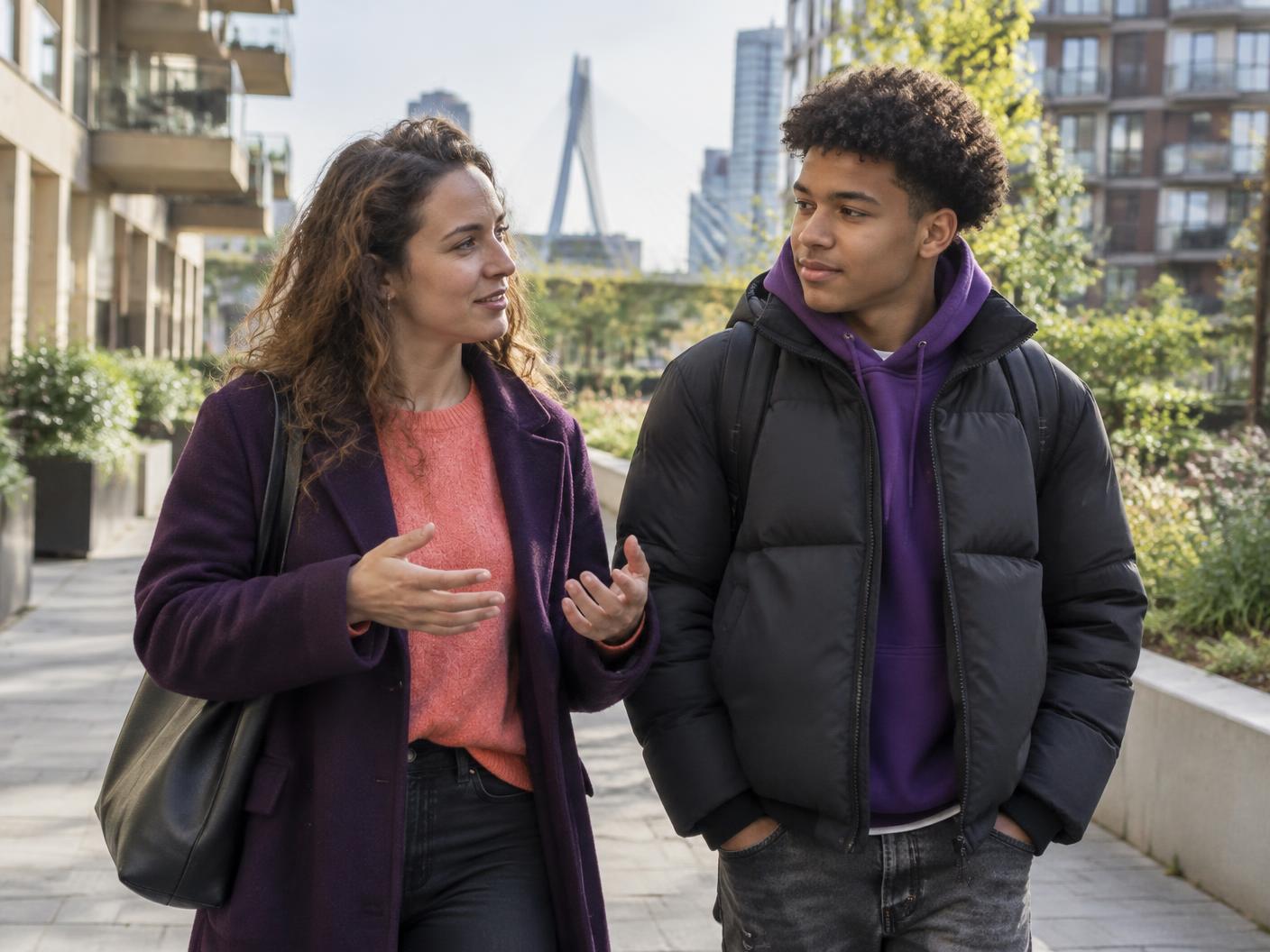 Een begeleider en jongere lopen samen door Rotterdam